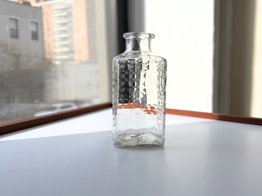 Vintage clear glass studded decanter shown upright, full body view