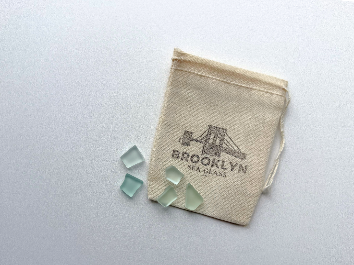 Brooklyn Sea Glass branded muslin packaging bag with tumbled sea glass pieces