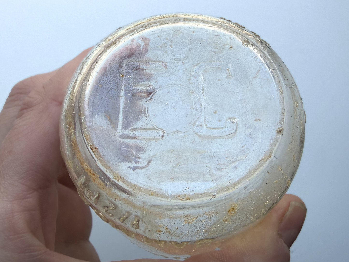 Close-up of bottle base in hand showing EC and 51 embossed marks dating the Elmhurst Cream Co bottle to 1951