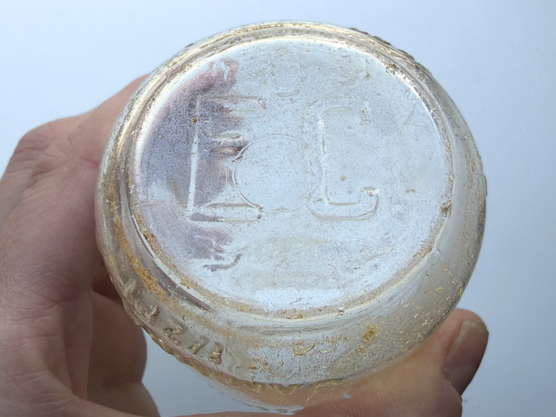 Close-up of bottle base in hand showing EC and 51 embossed marks dating the Elmhurst Cream Co bottle to 1951