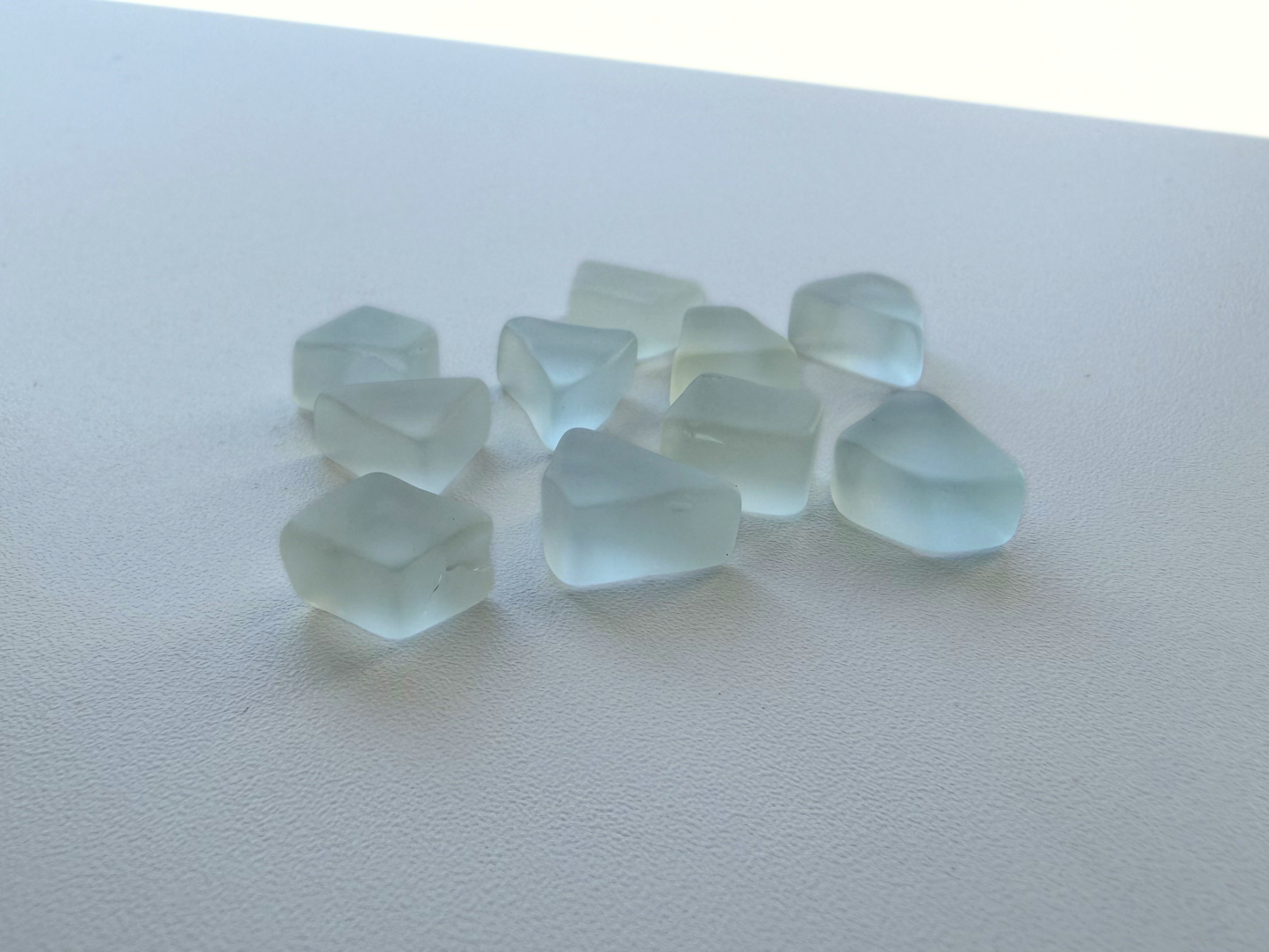 Detailed view of pale seafoam and sky blue flat tumbled sea glass pieces