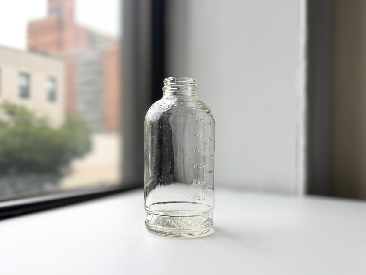 Clear glass Abbott Laboratories bottle on a windowsill, side profile.