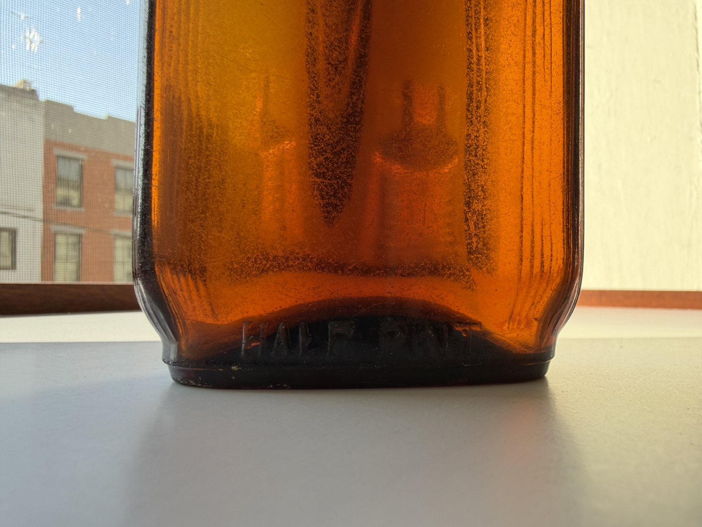Full body side view of a sea-worn amber glass Art Deco flask