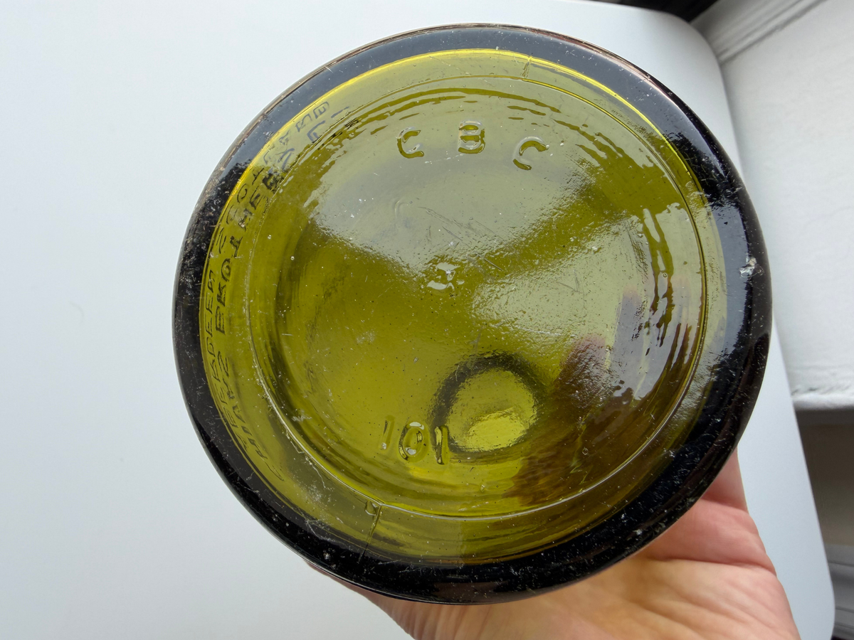 Base of the vintage green glass Chivas bottle held up to show the GBC 101 mark