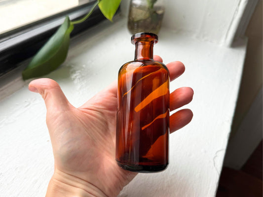 Amber apothecary bottle full profile view, cork-top pharmacy glass