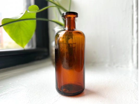 Amber cork-top apothecary bottle side view showing cork stopper