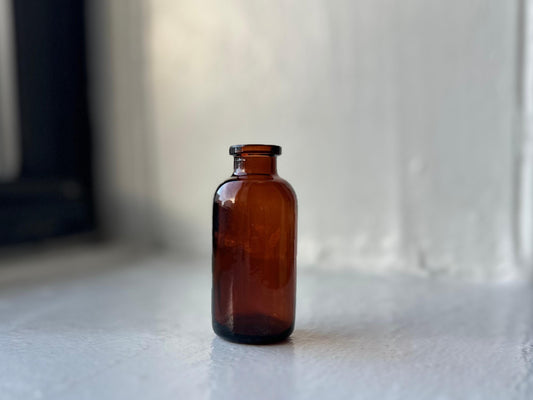 Amber glass medicine vial full front view, miniature 2.9 inch dispensing form, warm amber color, NYC recovery