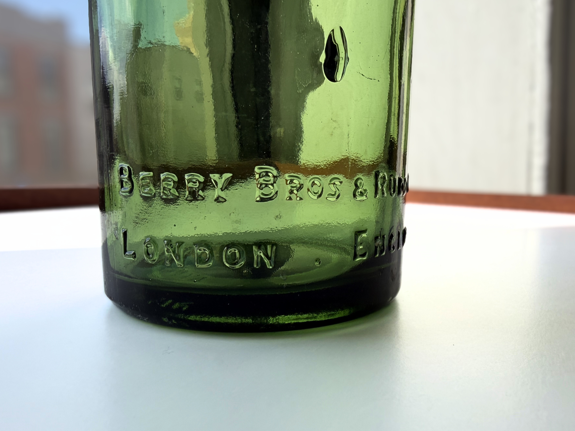 Close-up of BERRY BROS AND RUDD LTD LONDON ENGLAND front embossing on green glass Federal Law bottle
