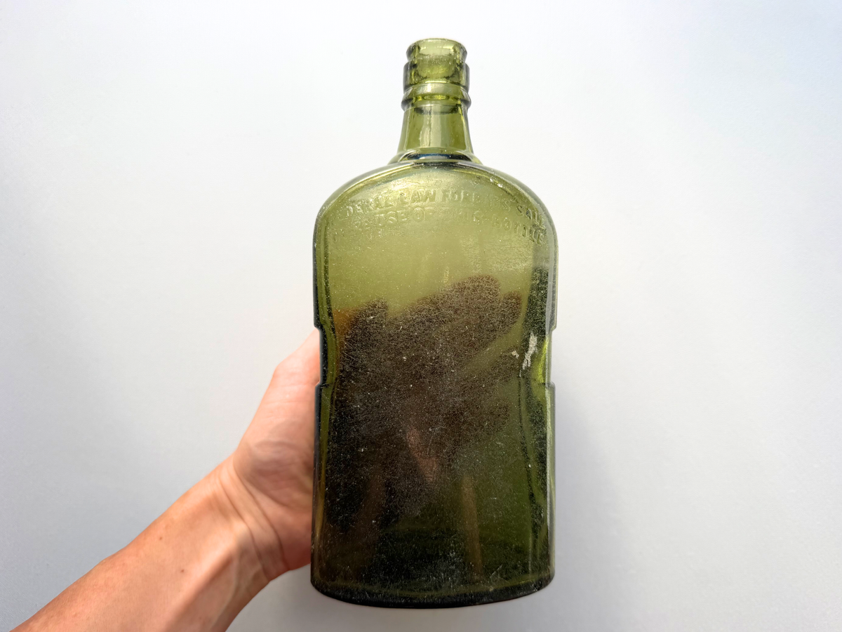 Black and White Deluxe Scotch bottle showing back Federal Law Forbids Sale embossing, vintage green glass
