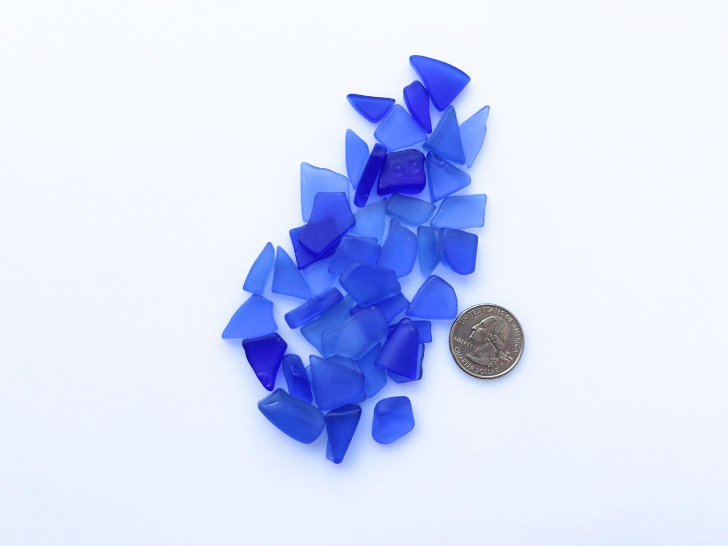 Deep blue sea glass with coin for size reference – all pieces under ¾ inch