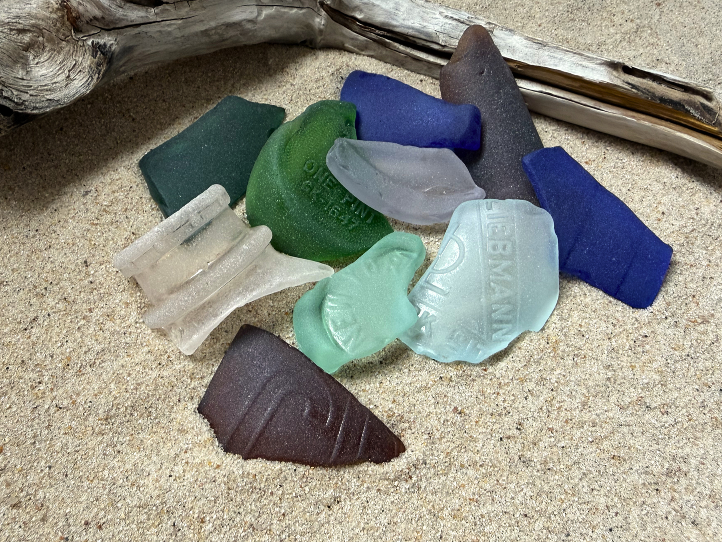 Large authentic NYC sea glass 2-3 inches on sand, colorful collection with embossed Liebmann marking and driftwood