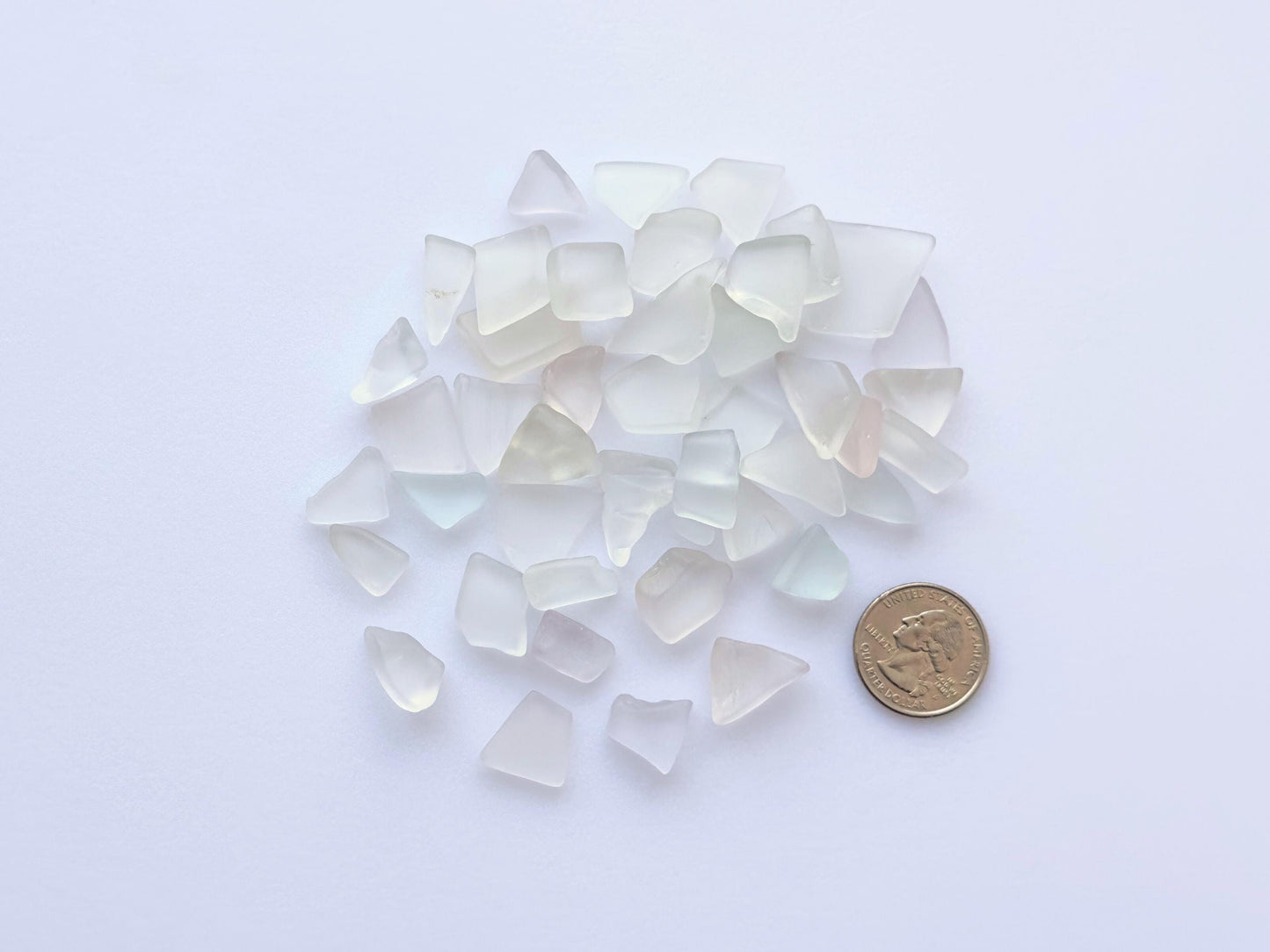 Pastel sea glass mix with coin for size reference – includes pale pink, yellow, green, blue, and purple glass pieces