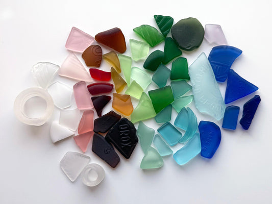 Machine-tumbled antique glass in a rainbow mix including green, amber, cobalt, red, and rare white rings. Each piece is repurposed from vintage bottles or tableware. Soft, frosted finish and rounded edges. “Best Seller” badge highlights its popularit