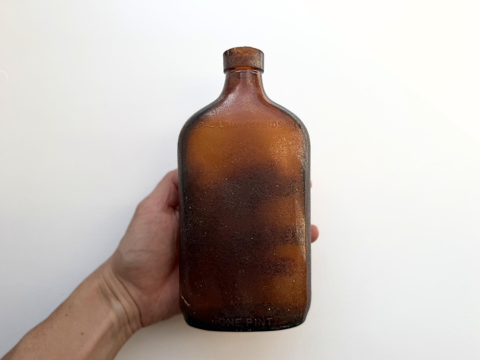 Authentic 1953 amber pint flask 7.75 inches tall with heavy all-over sea-worn patina and Federal Law embossing - genuine beach-found NYC sea glass hand-recovered from NYC shorelines