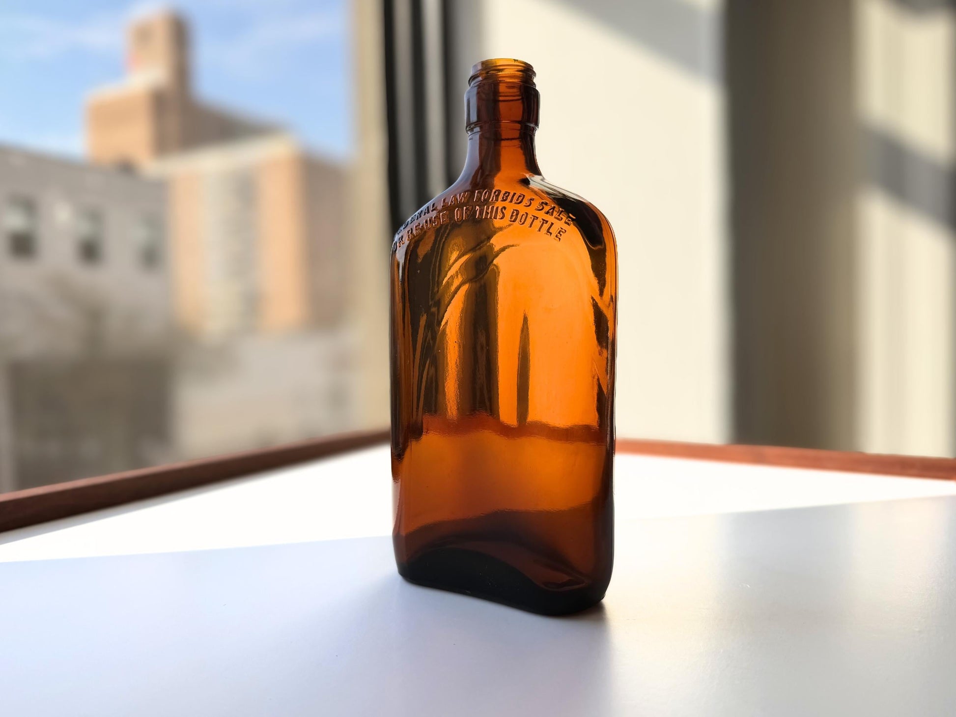 Vintage 1949 amber glass spirits flask 8.25 inches tall with Federal Law embossing around shoulder - clean mid-century collector piece hand-recovered from NYC