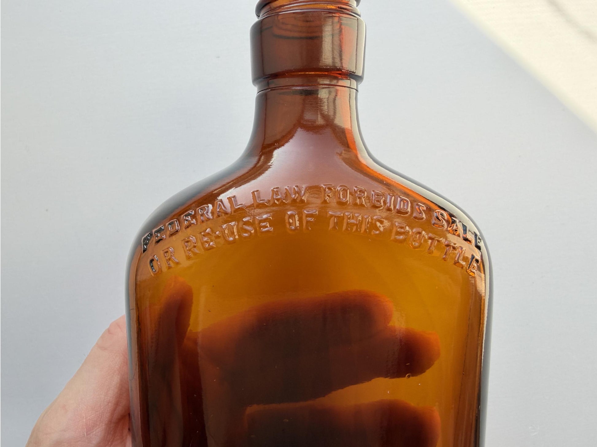 Vintage 1949 amber glass spirits flask 8.25 inches tall with Federal Law embossing around shoulder - clean mid-century collector piece hand-recovered from NYC