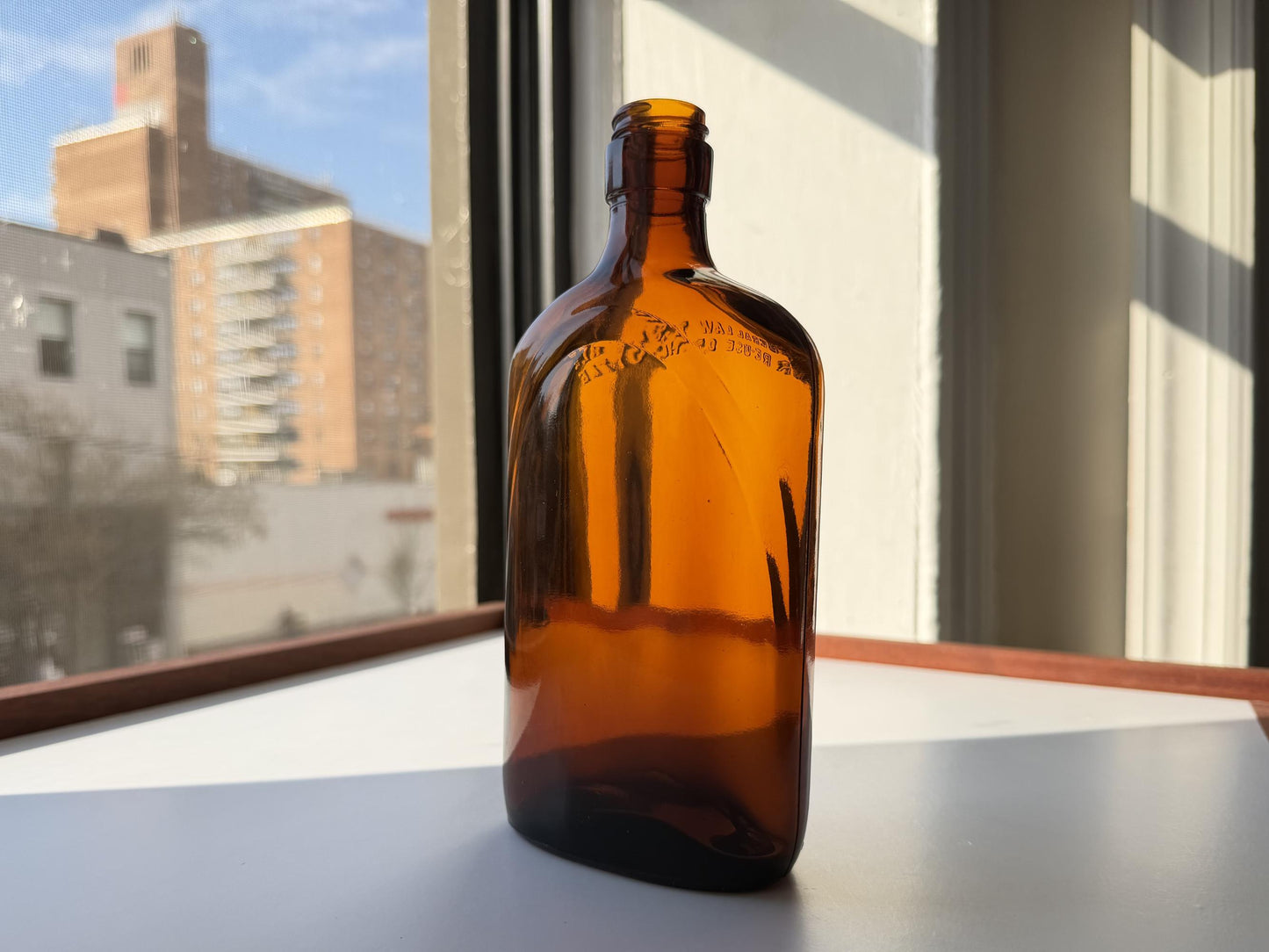 Vintage 1949 amber glass spirits flask 8.25 inches tall with Federal Law embossing around shoulder - clean mid-century collector piece hand-recovered from NYC