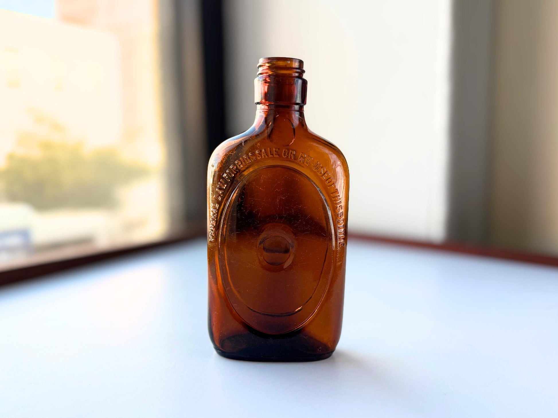 Vintage 1950s amber glass liquor flask 6.75 inches tall with oval embossing and Federal Law prohibition warning. Art Deco oval design, rescued from NYC historic landfills – Brooklyn Sea Glass