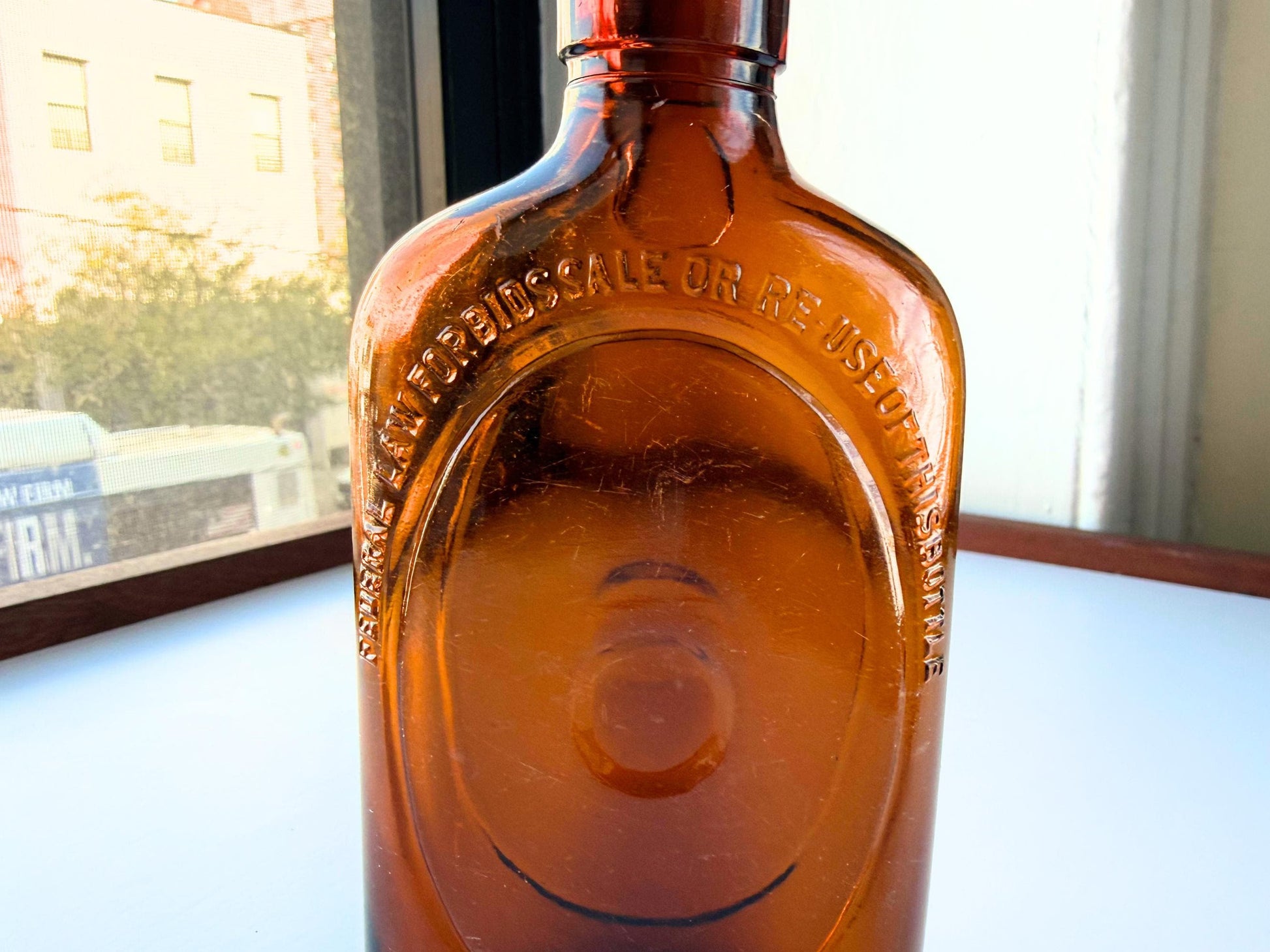 Vintage 1950s amber glass liquor flask 6.75 inches tall with oval embossing and Federal Law prohibition warning. Art Deco oval design, rescued from NYC historic landfills – Brooklyn Sea Glass
