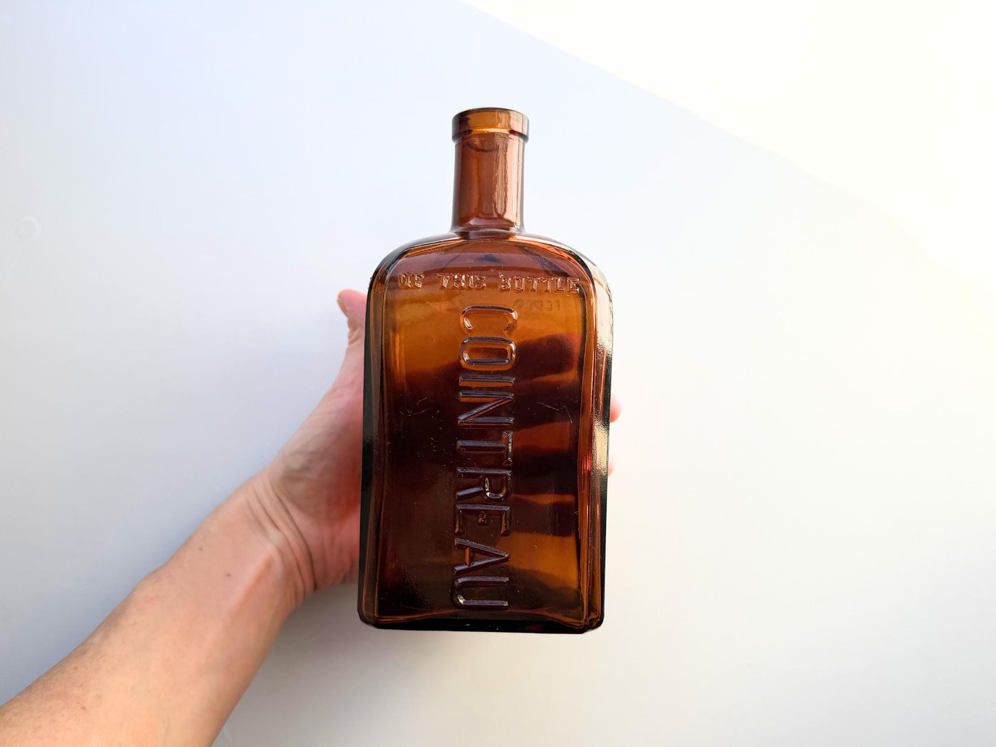 Vintage 1951 large amber Cointreau bottle with 51 production marking. Perfect for spirits collectors, bar displays, and vintage liqueur enthusiasts.