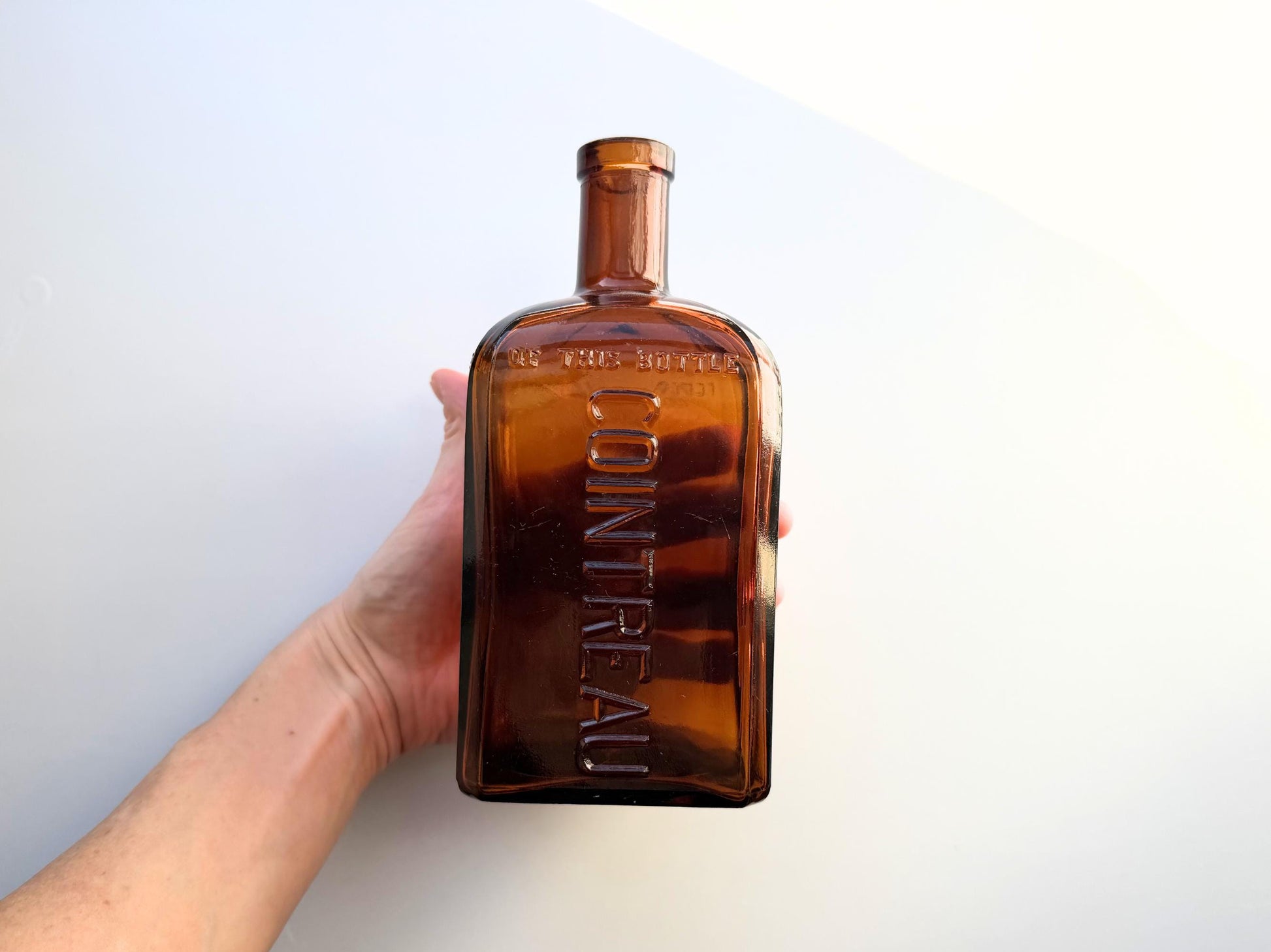 Vintage 1951 large amber Cointreau bottle with 51 production marking. Perfect for spirits collectors, bar displays, and vintage liqueur enthusiasts.