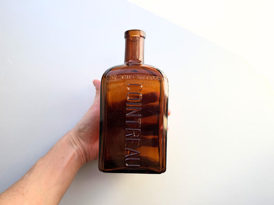Vintage 1951 large amber Cointreau bottle with 51 production marking. Perfect for spirits collectors, bar displays, and vintage liqueur enthusiasts.
