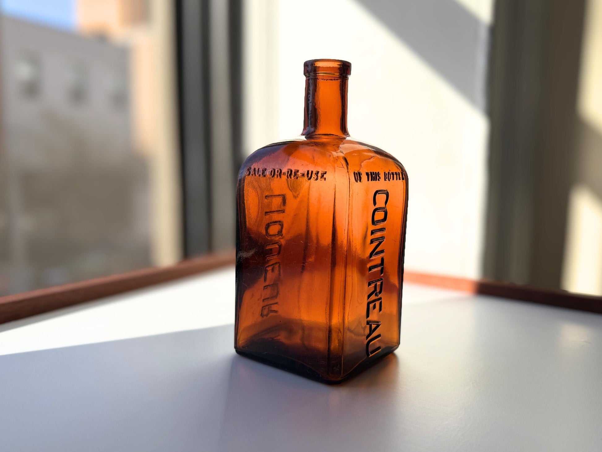 Vintage 1951 large amber Cointreau bottle with 51 production marking. Perfect for spirits collectors, bar displays, and vintage liqueur enthusiasts.
