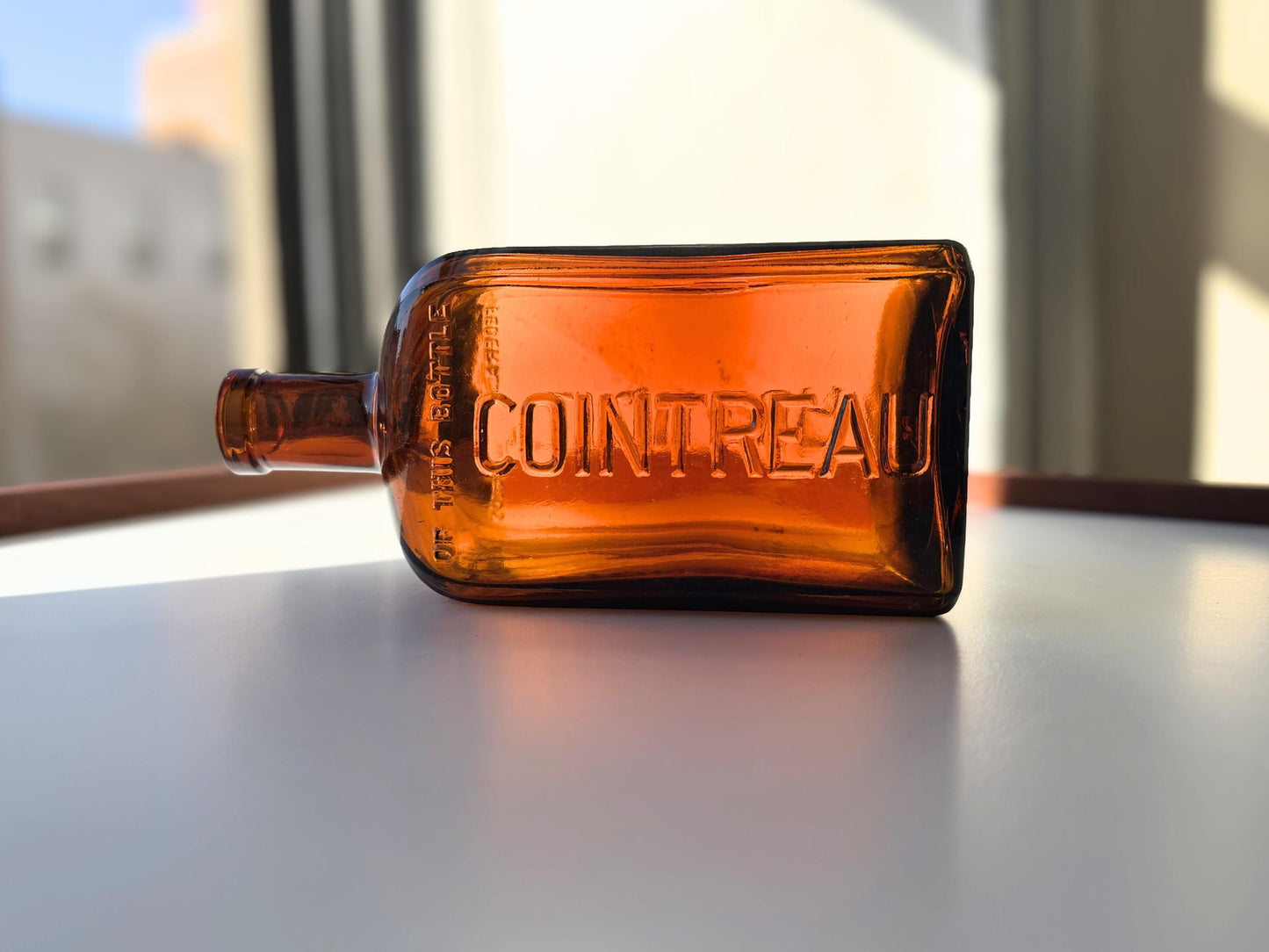Vintage 1951 large amber Cointreau bottle with 51 production marking. Perfect for spirits collectors, bar displays, and vintage liqueur enthusiasts.