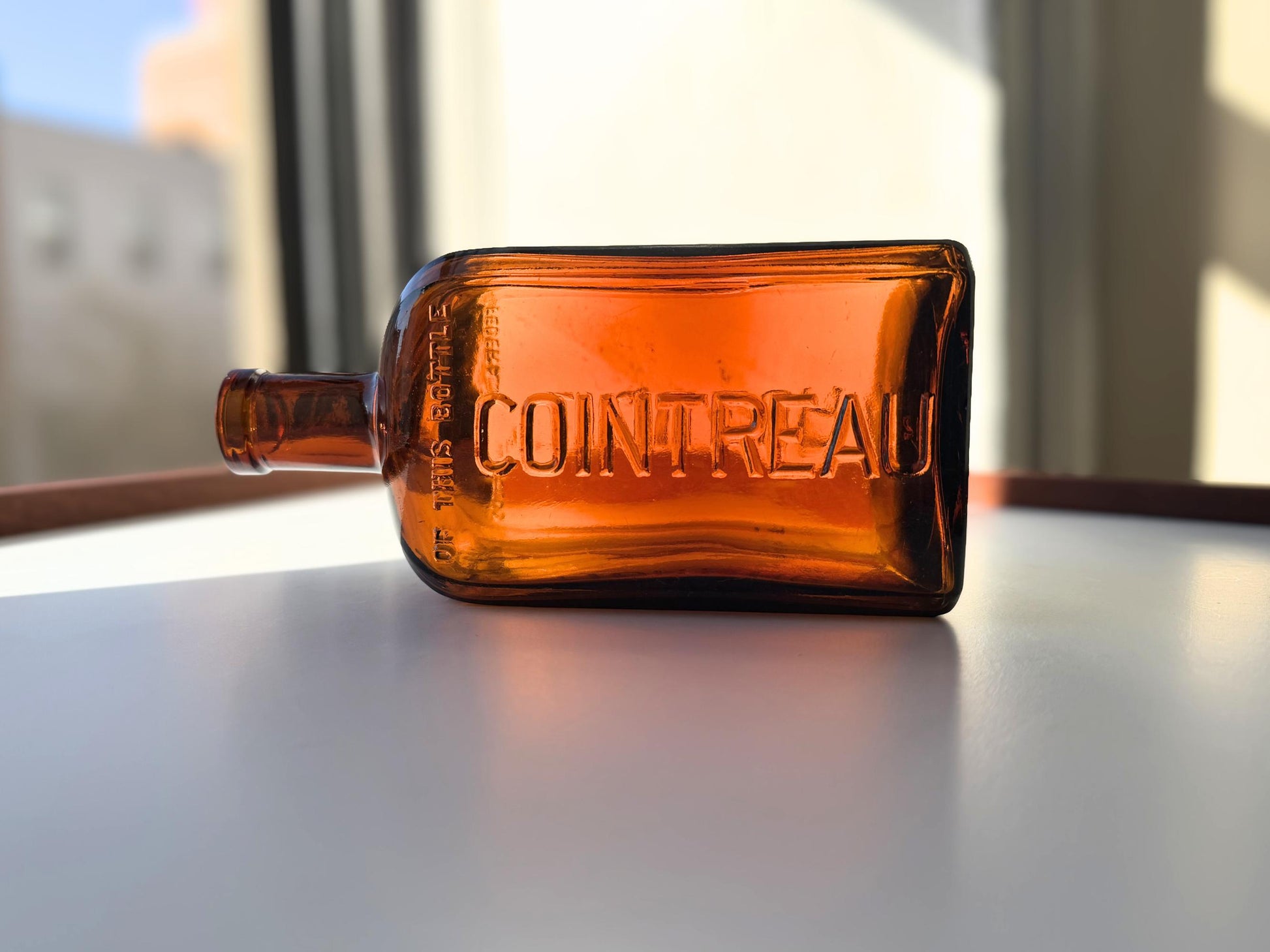 Vintage 1951 large amber Cointreau bottle with 51 production marking. Perfect for spirits collectors, bar displays, and vintage liqueur enthusiasts.