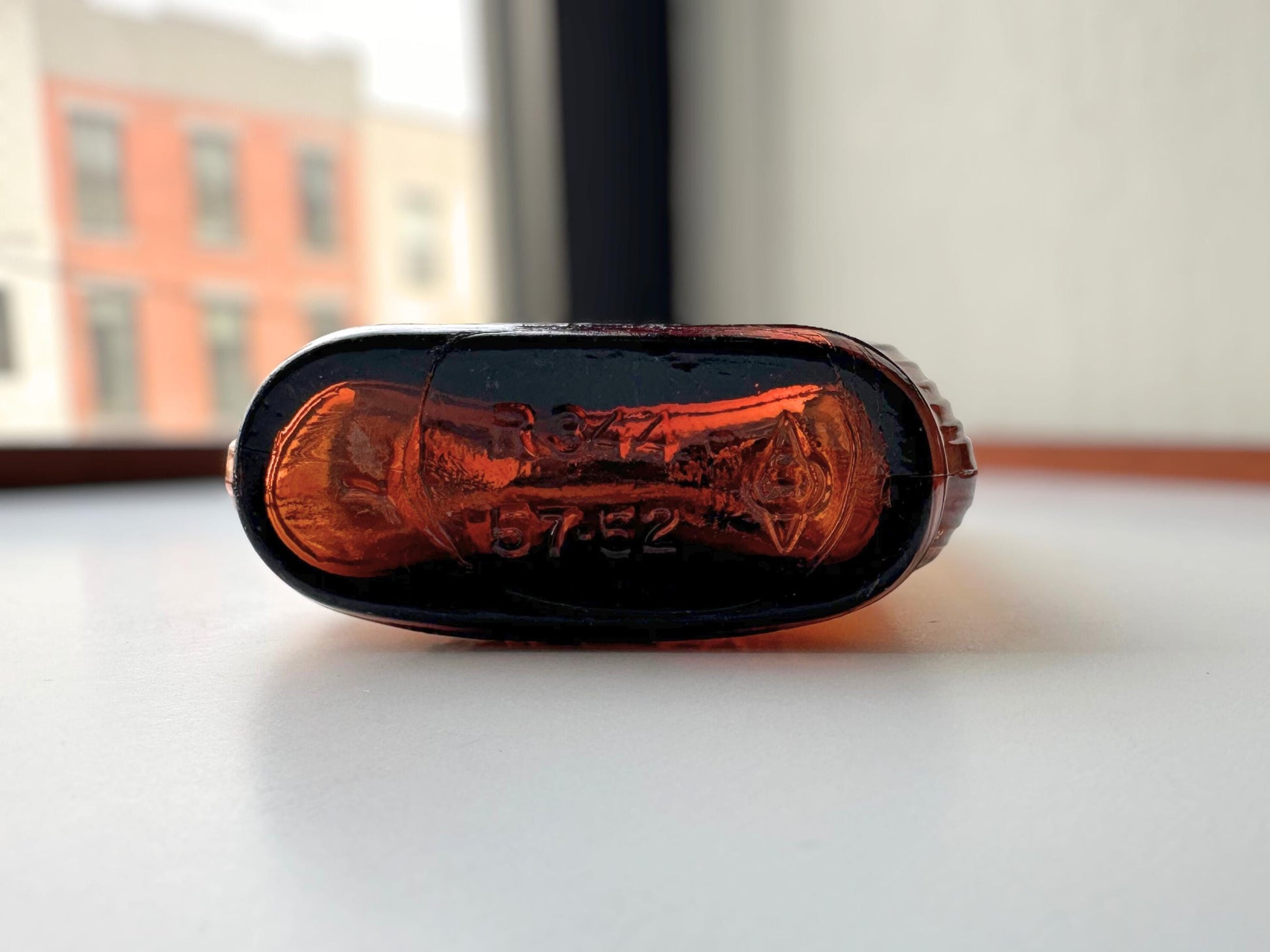 Vintage 1952 mid-century amber glass flask 7.5 inches tall by 3.4 inches wide, rescued from NYC beaches. Ribbed design with embossed Federal Law Forbids Sale Or Reuse Of This Bottle text – Brooklyn Sea Glass