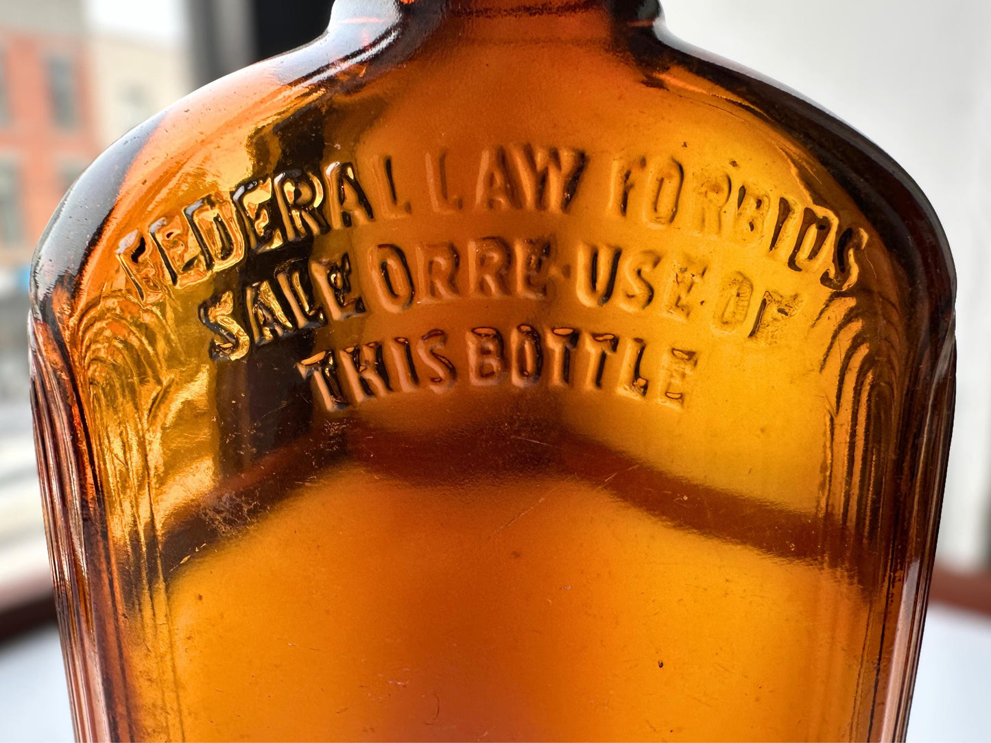 Vintage 1952 mid-century amber glass flask 7.5 inches tall by 3.4 inches wide, rescued from NYC beaches. Ribbed design with embossed Federal Law Forbids Sale Or Reuse Of This Bottle text – Brooklyn Sea Glass