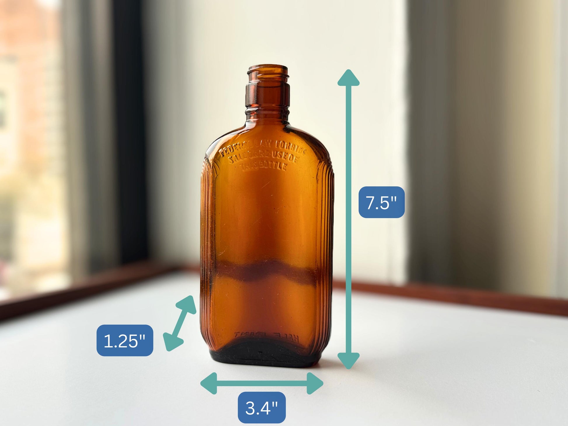 Vintage 1952 mid-century amber glass flask 7.5 inches tall by 3.4 inches wide, rescued from NYC beaches. Ribbed design with embossed Federal Law Forbids Sale Or Reuse Of This Bottle text – Brooklyn Sea Glass