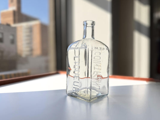 Vintage 1952 Cointreau clear glass liqueur flask 7.5 inches tall with COINTREAU and LIQUEUR embossing - French spirits collector piece hand-recovered from NYC, small chip on mouth
