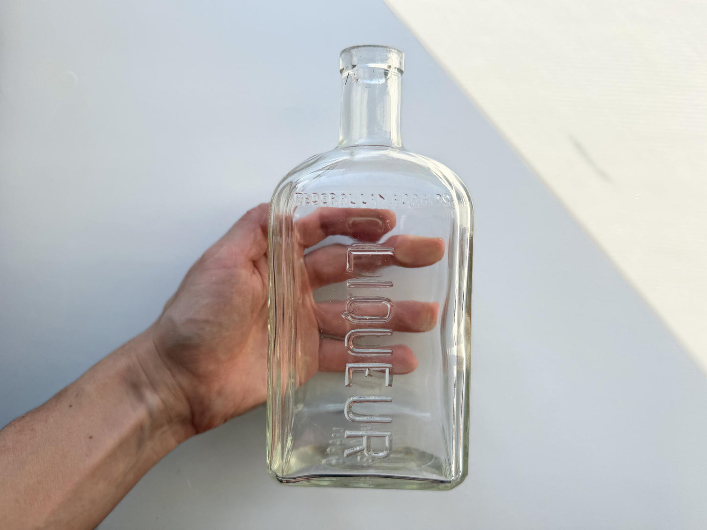 Vintage 1952 Cointreau clear glass liqueur flask 7.5 inches tall with COINTREAU and LIQUEUR embossing - French spirits collector piece hand-recovered from NYC, small chip on mouth