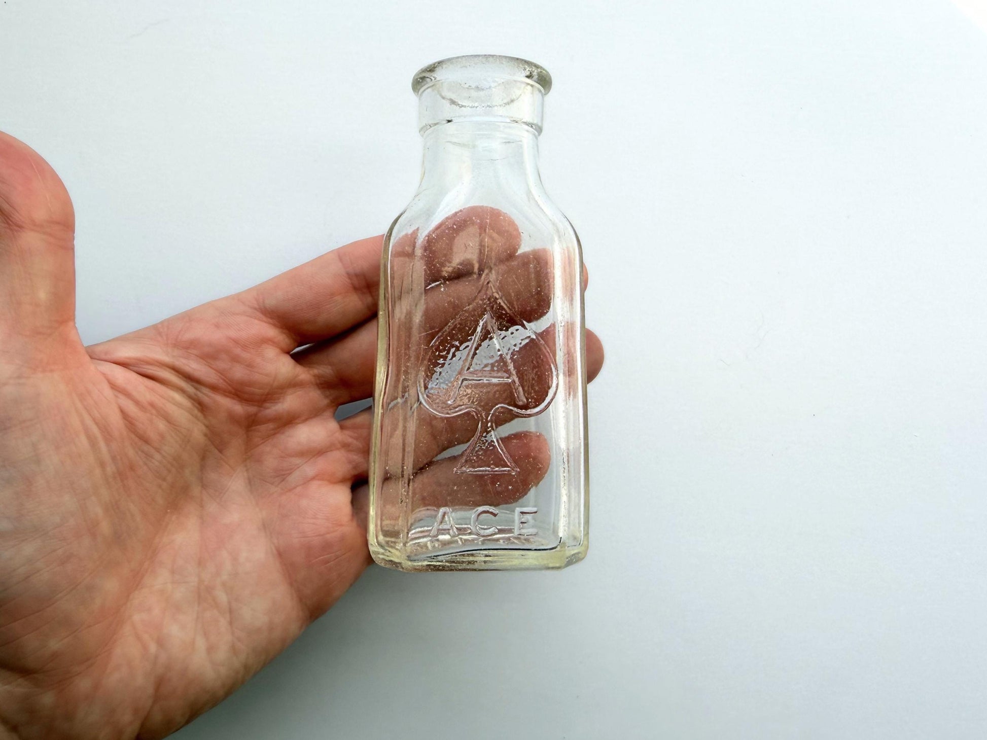 Vintage clear glass Ace shoe polish bottle 4.25 inches tall with bold ace-of-spades embossed logo - mid-century American collector piece hand-recovered from NYC