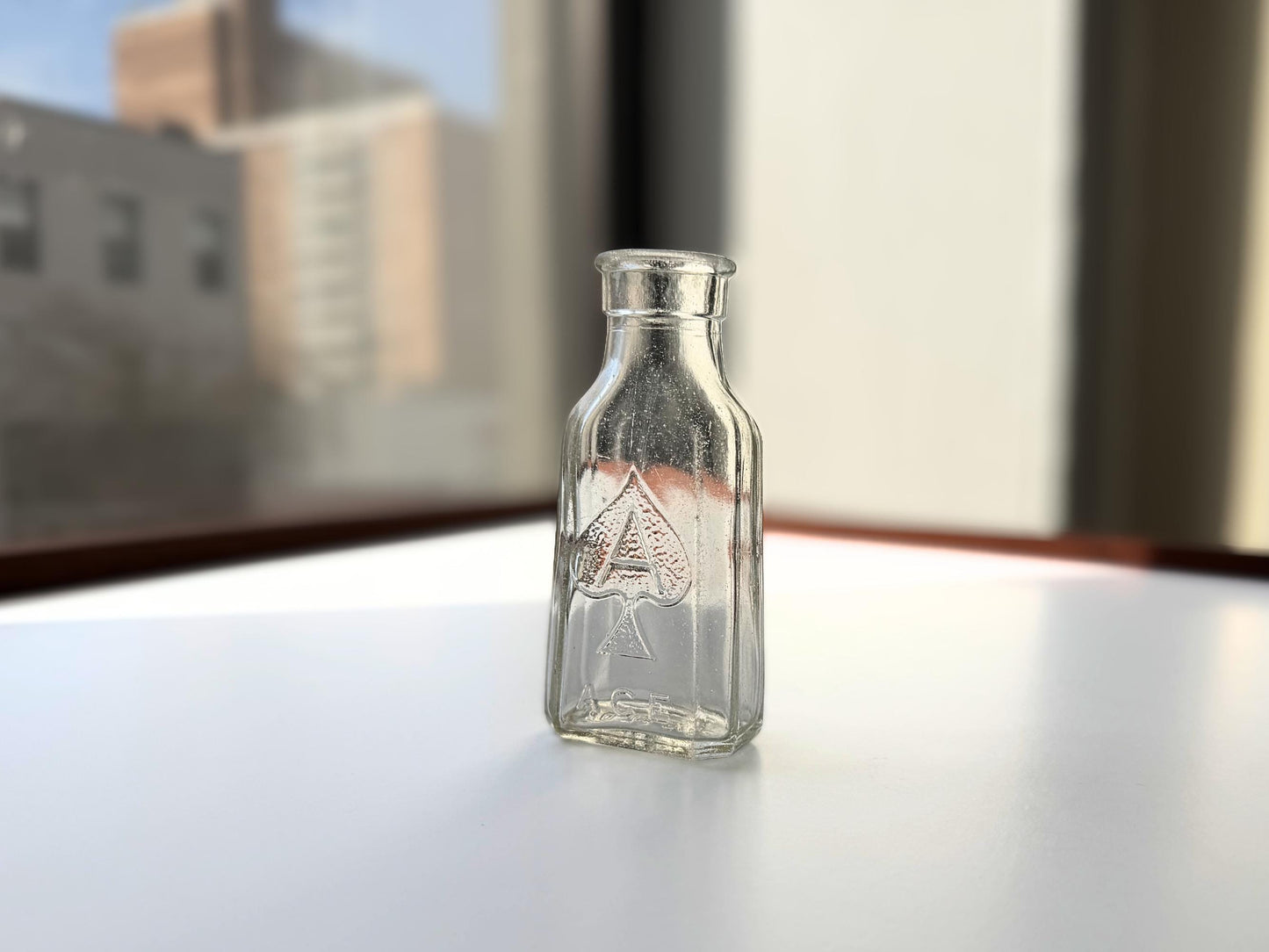 Vintage clear glass Ace shoe polish bottle 4.25 inches tall with bold ace-of-spades embossed logo - mid-century American collector piece hand-recovered from NYC
