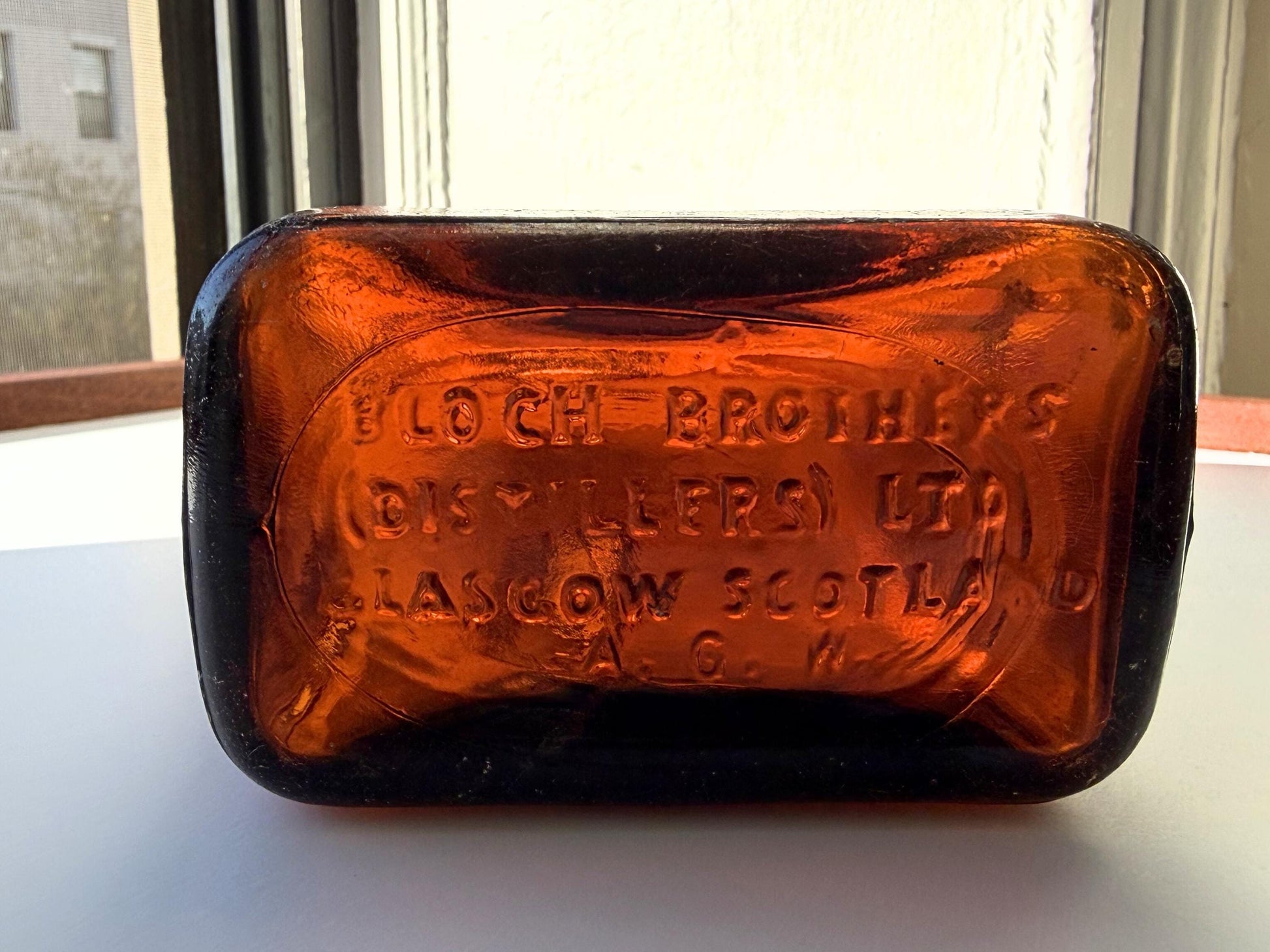 Vintage Bloch Brothers whisky bottle from Glasgow Scotland with distillery marking. Good condition showing minor scratches. Perfect for Scottish whisky collectors.