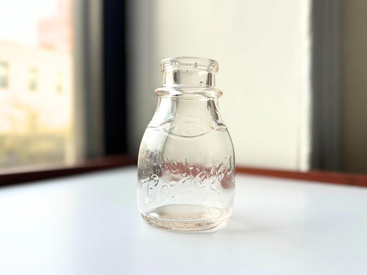 Vintage Borden's clear glass milk bottle, 4.75 inches tall, hand-recovered from NYC mid-century dumping grounds — authentic half-pint dairy bottle with hand-blown character