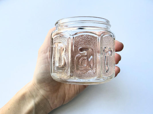 Vintage Barbasol clear glass shave jar with embossed design and metal lid, measuring 3.25 inches tall. Features original Barbasol branding and patent markings on the bottom. Perfect for bathroom display, vintage collections, or cottagecore home decor.
