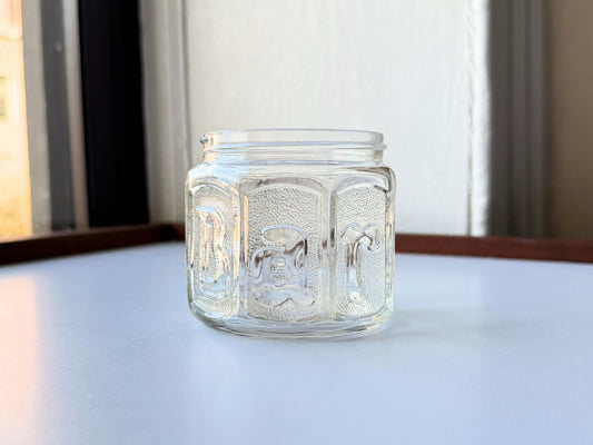 Vintage Barbasol clear glass shave jar with embossed design and metal lid, measuring 3.25 inches tall. Features original Barbasol branding and patent markings on the bottom. Perfect for bathroom display, vintage collections, or cottagecore home decor.