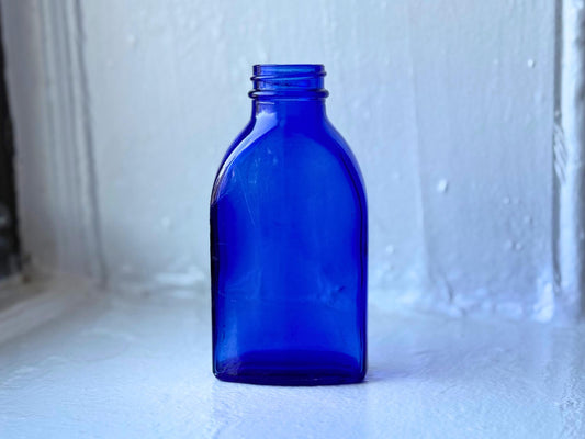 Rear view of the vintage cobalt blue medicine bottle highlighting its flat rectangular back and smooth glass surface – Brooklyn Sea Glass