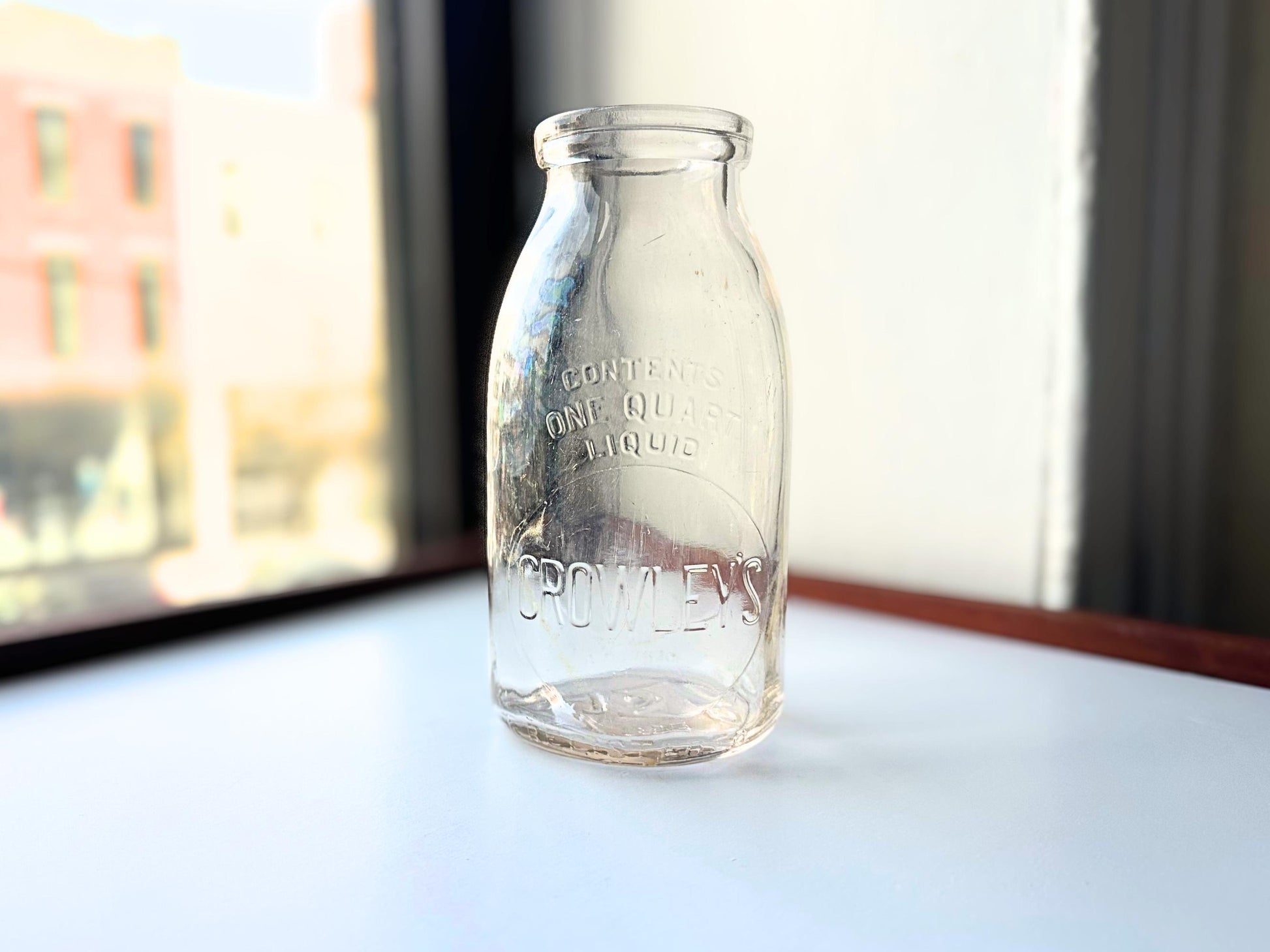 Vintage Crowley's one quart milk bottle with pink tinted glass and embossed Fine Quality lettering. Perfect for farmhouse cottagecore vintage kitchen decor, single stem vase, flower display, or dairy bottle collection. Rescued from NYC beaches.