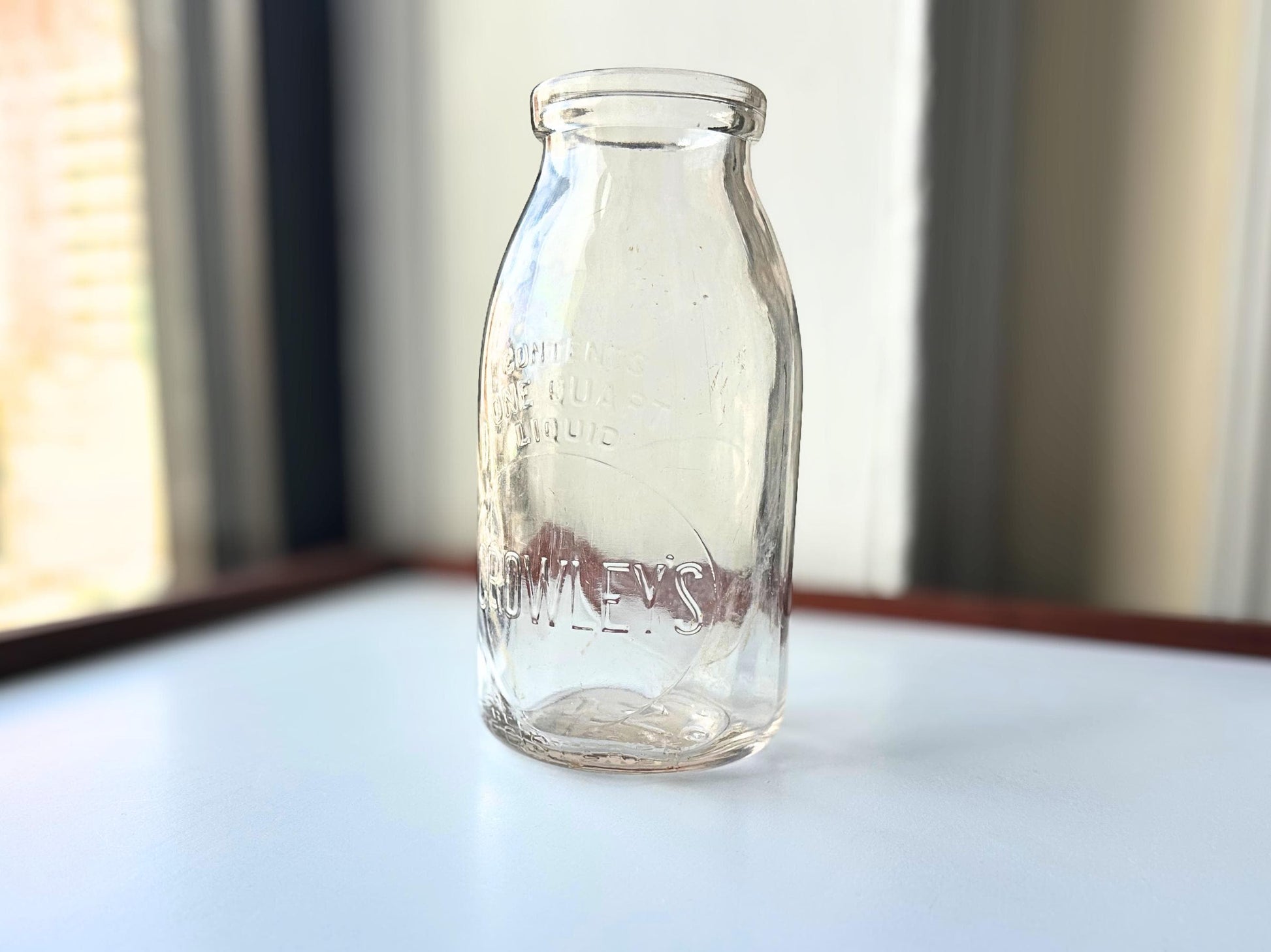 Vintage Crowley's one quart milk bottle with pink tinted glass and embossed Fine Quality lettering. Perfect for farmhouse cottagecore vintage kitchen decor, single stem vase, flower display, or dairy bottle collection. Rescued from NYC beaches.
