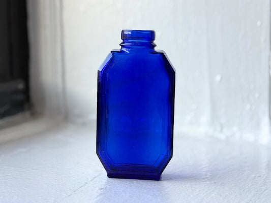 Frontal view of vintage Evening in Paris cobalt blue glass bottle by Bourjois showcasing its elegant Art Deco design – Brooklyn Sea Glass
