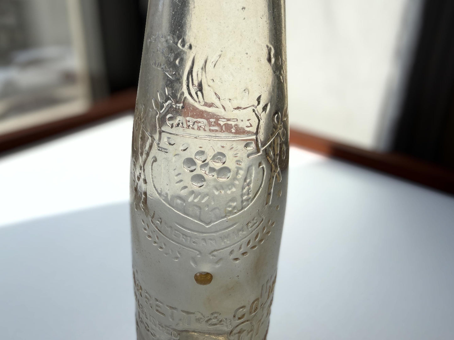Vintage Garrett and Co Virginia Dare clear glass wine bottle 8.75 inches tall with full-body embossed crest and pre-Prohibition text - hand-recovered from NYC dumping grounds