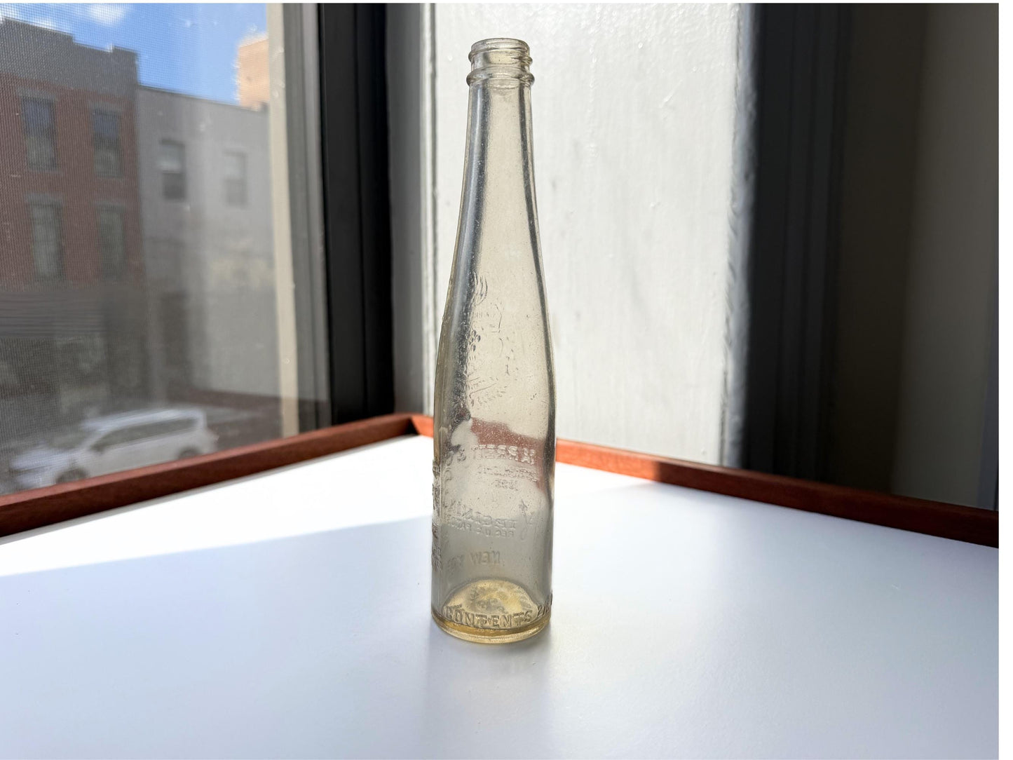Vintage Garrett and Co Virginia Dare clear glass wine bottle 8.75 inches tall with full-body embossed crest and pre-Prohibition text - hand-recovered from NYC dumping grounds