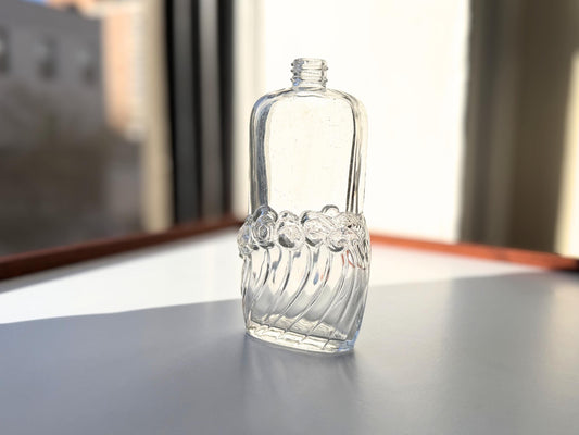 Vintage glass waves textured bottle with distinctive wavy pattern throughout. Clear glass with light patina. Perfect for vintage glass collectors and pattern enthusiasts.