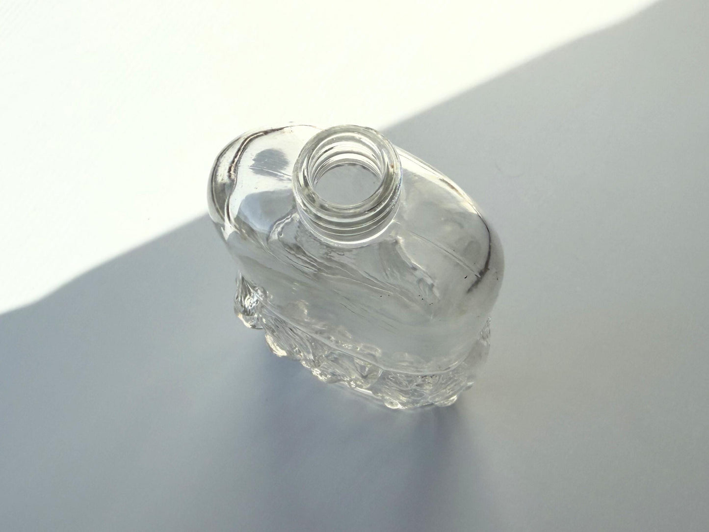 Vintage glass waves textured bottle with distinctive wavy pattern throughout. Clear glass with light patina. Perfect for vintage glass collectors and pattern enthusiasts.