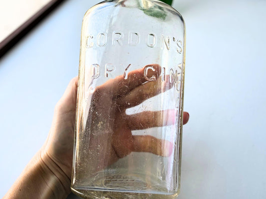 Close-up of GORDON'S front embossing on mid-century London Dry Gin clear glass bottle