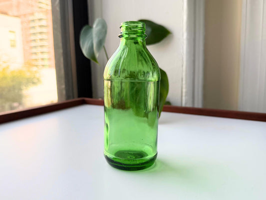 Vintage 1945 green glass beverage bottle from Glenshaw Glass Company with vibrant emerald color. Perfect for bookshelf styling, bud vases, farmhouse decor, and cottagecore displays – Brooklyn Sea Glass